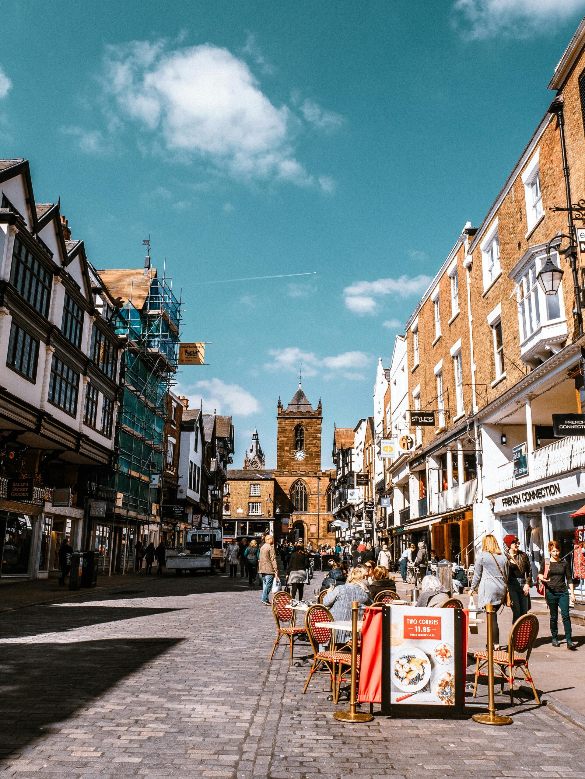 a row of shops on a busy high-street on a cloudy day
